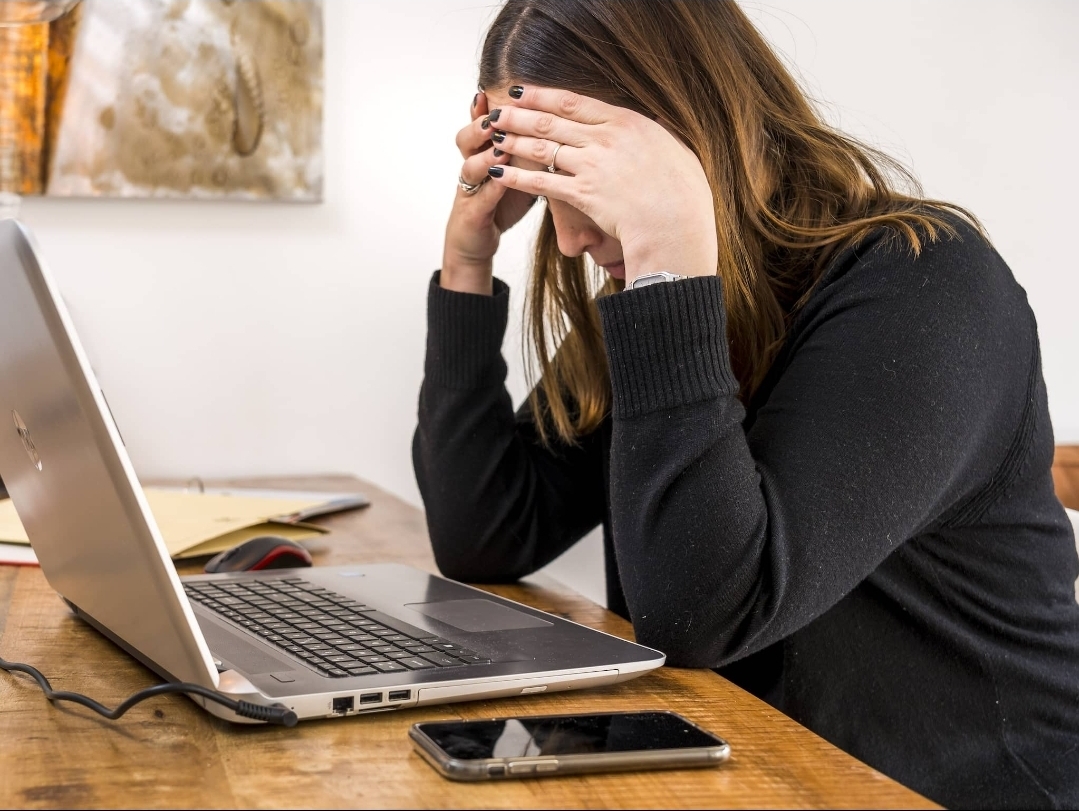 Medewerker ervaart stress en hoge werkdruk achter haar laptop